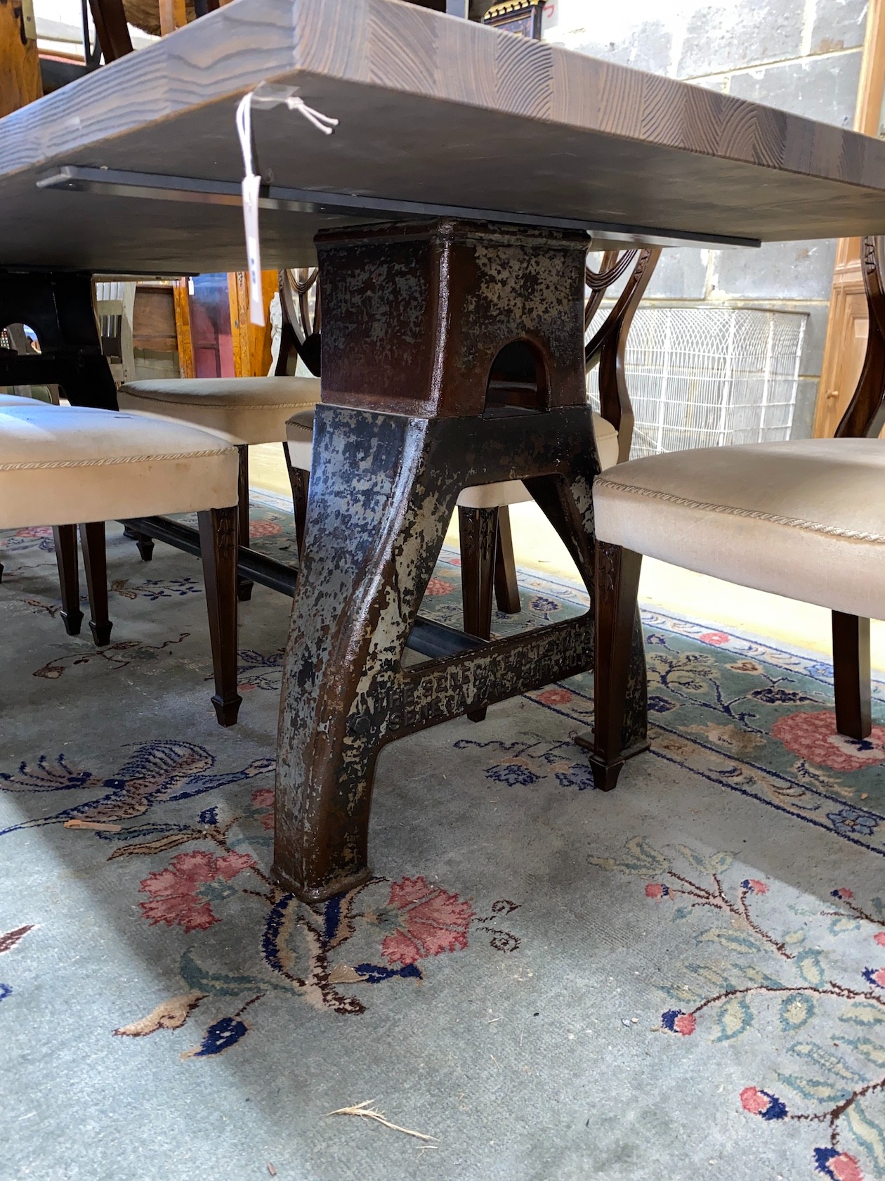 A contemporary industrial style rectangular bleached wood dining table on cast metal base, length 240cm, depth 101cm, height 76cm